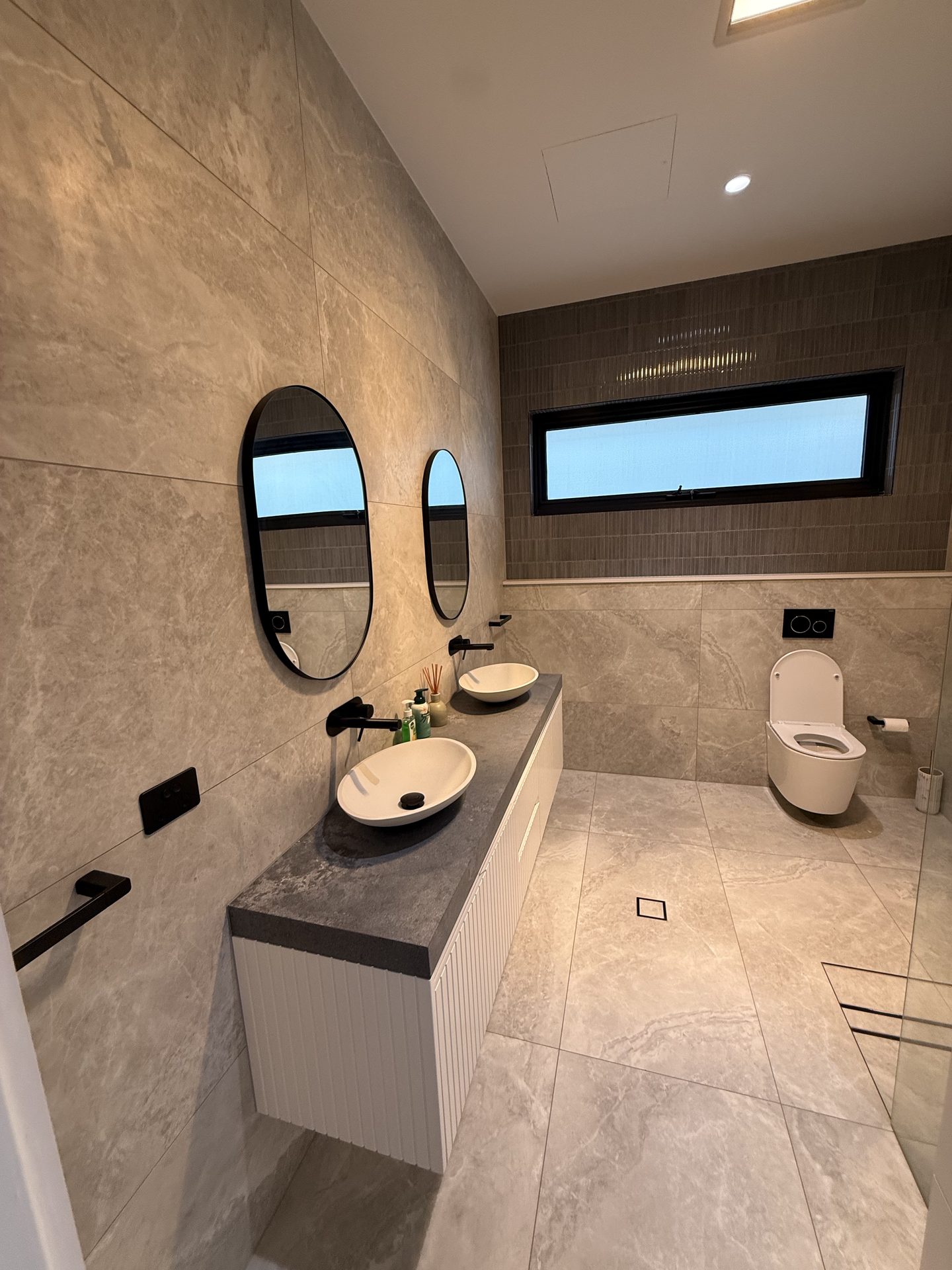 Contemporary bathroom renovation with matte tiles and niche — Sydney