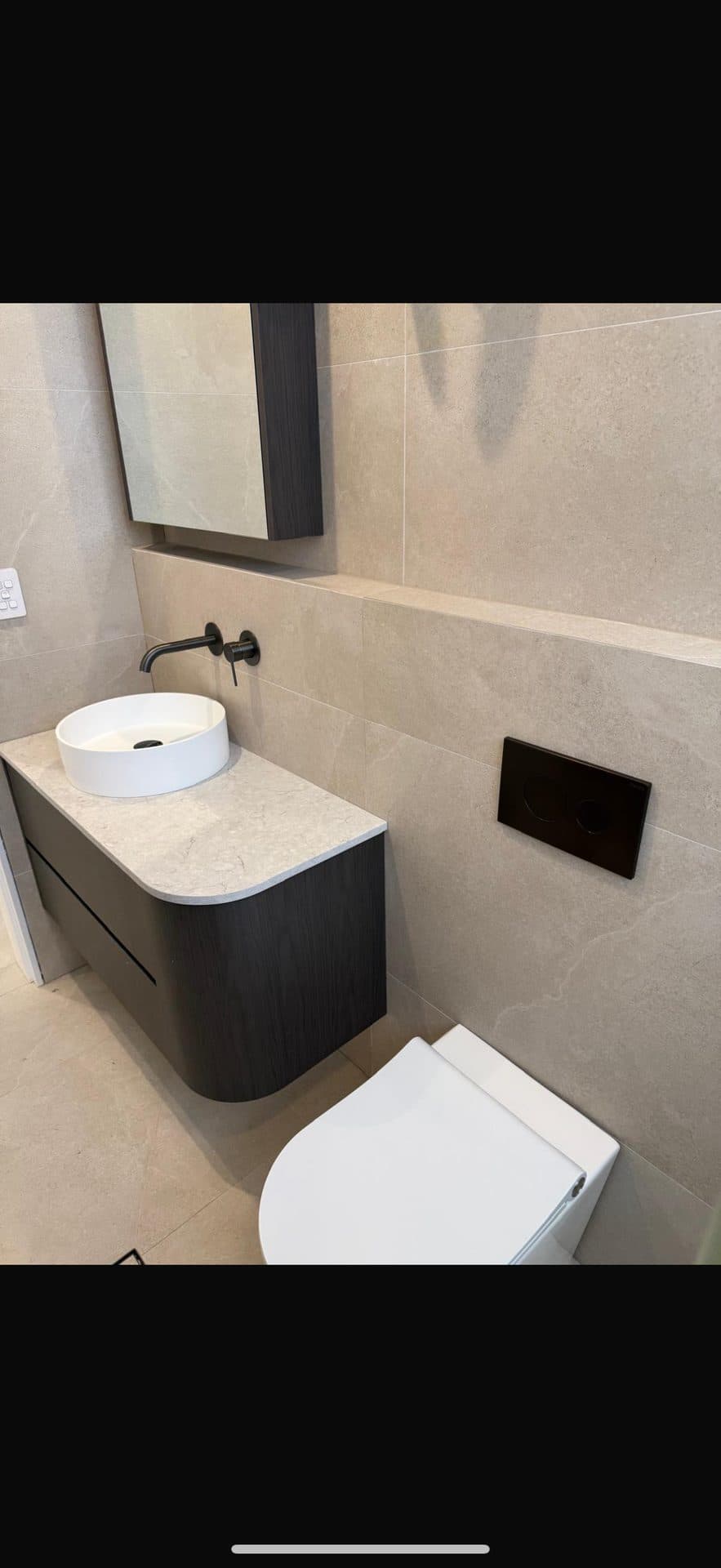Dark vanity powder room tiling — bathroom renovation Sydney