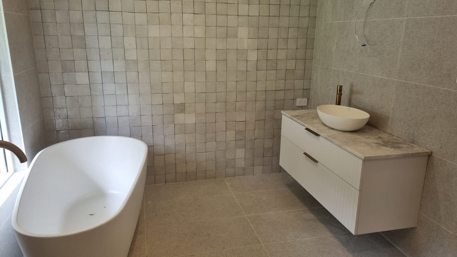 Freestanding bath with zellige feature wall — bathroom tiling Sydney